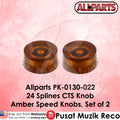 Amber speed knobs with Allparts branding on a pink background