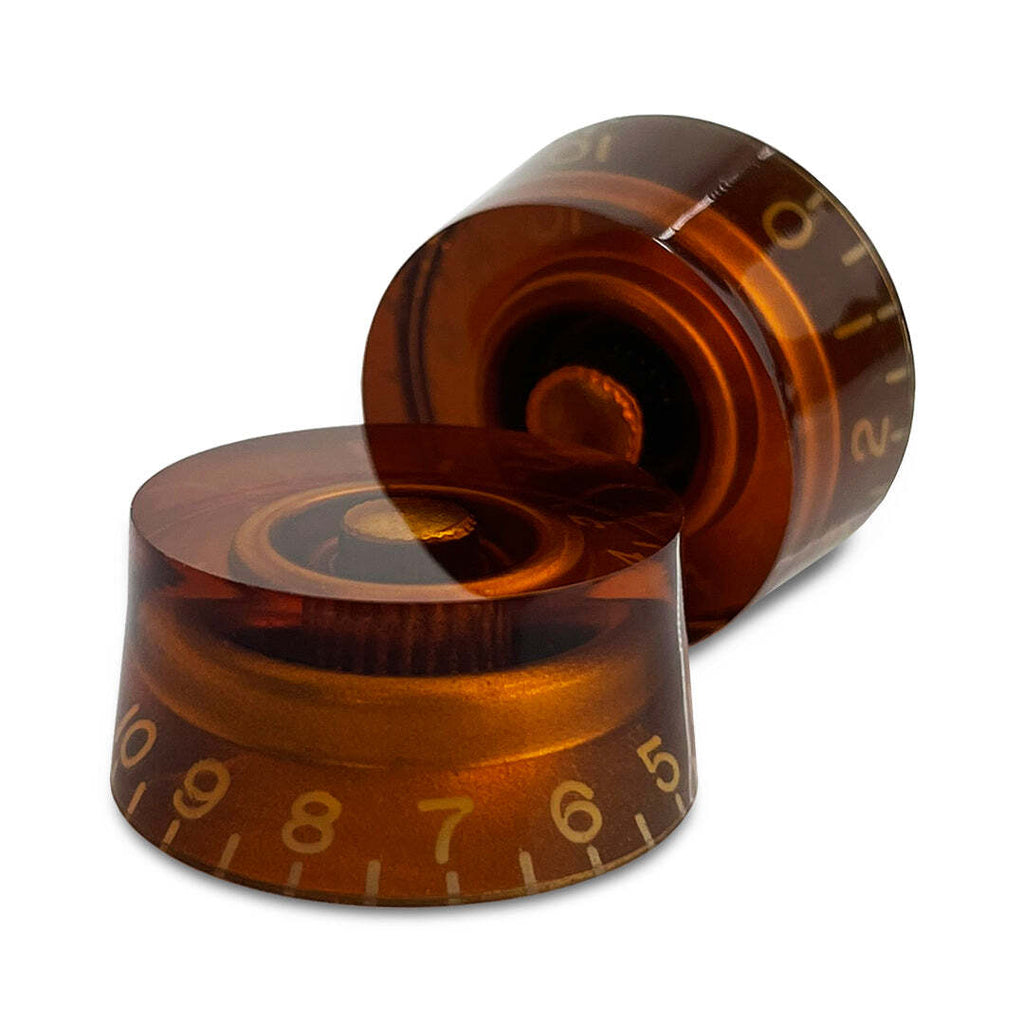 Two amber-colored guitar tuning pegs with number markings on a white background