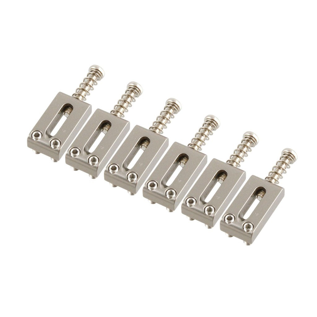 Set of six metallic guitar bridge components on a white background