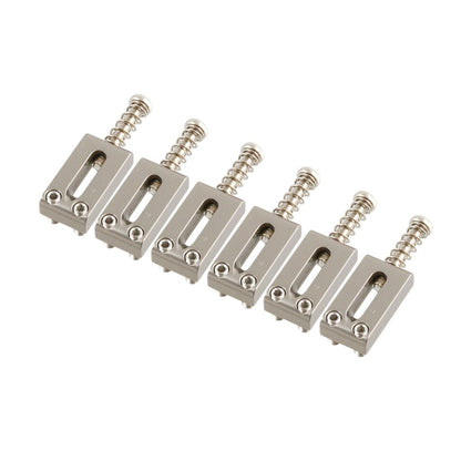 Set of six metallic guitar bridge components on a white background