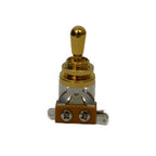 A small gold-toned toggle switch with a polished metal lever, knurled adjustment collar, clear glass or plastic window, and a copper-colored base with two silver screws, shown on a plain white background.