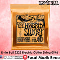 Ernie Ball Hybrid Slinky 2222 electric guitar strings in a gold foil package, displayed against a pink textured background with brand and seller text overlays.
