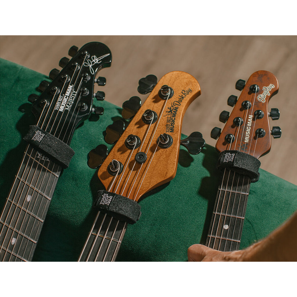 Three electric guitars with different headstock designs on a green surface.