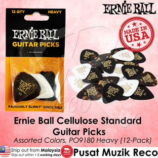 Ernie Ball heavy guitar picks in assorted black, white, and tortoiseshell colors, shown in their original retail packaging alongside a pile of loose picks on a pink background with product text and branding.