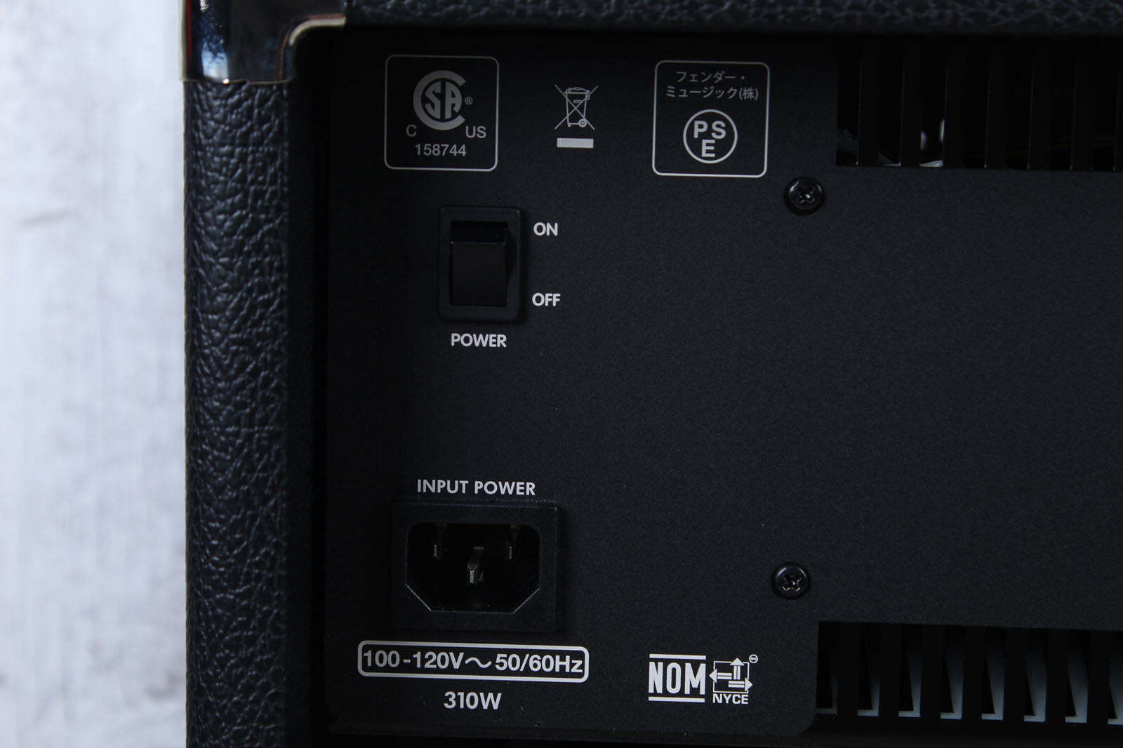 Back panel of a black electronic device with power switch and input/output ports.
