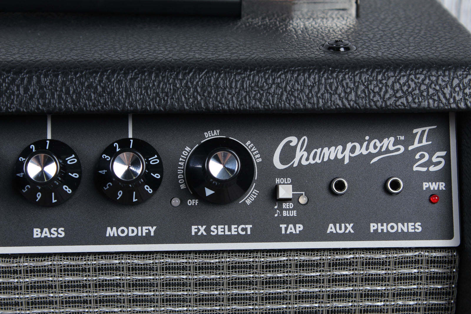 Close-up of a Champion II 25 guitar amplifier panel with control knobs and labels.