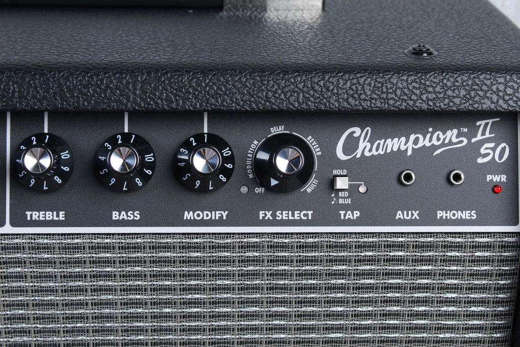Close-up of a Champion II 50 guitar amplifier with control knobs and labels.