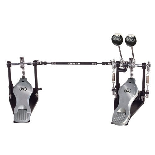A double bass drum pedal system by Gibraltar, featuring two silver foot pedals with black accents, a black horizontal bar, and black drumheads, shown against a solid white background.