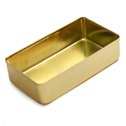 A rectangular gold metal tin with a shallow interior, shown at an angle on a plain white background.
