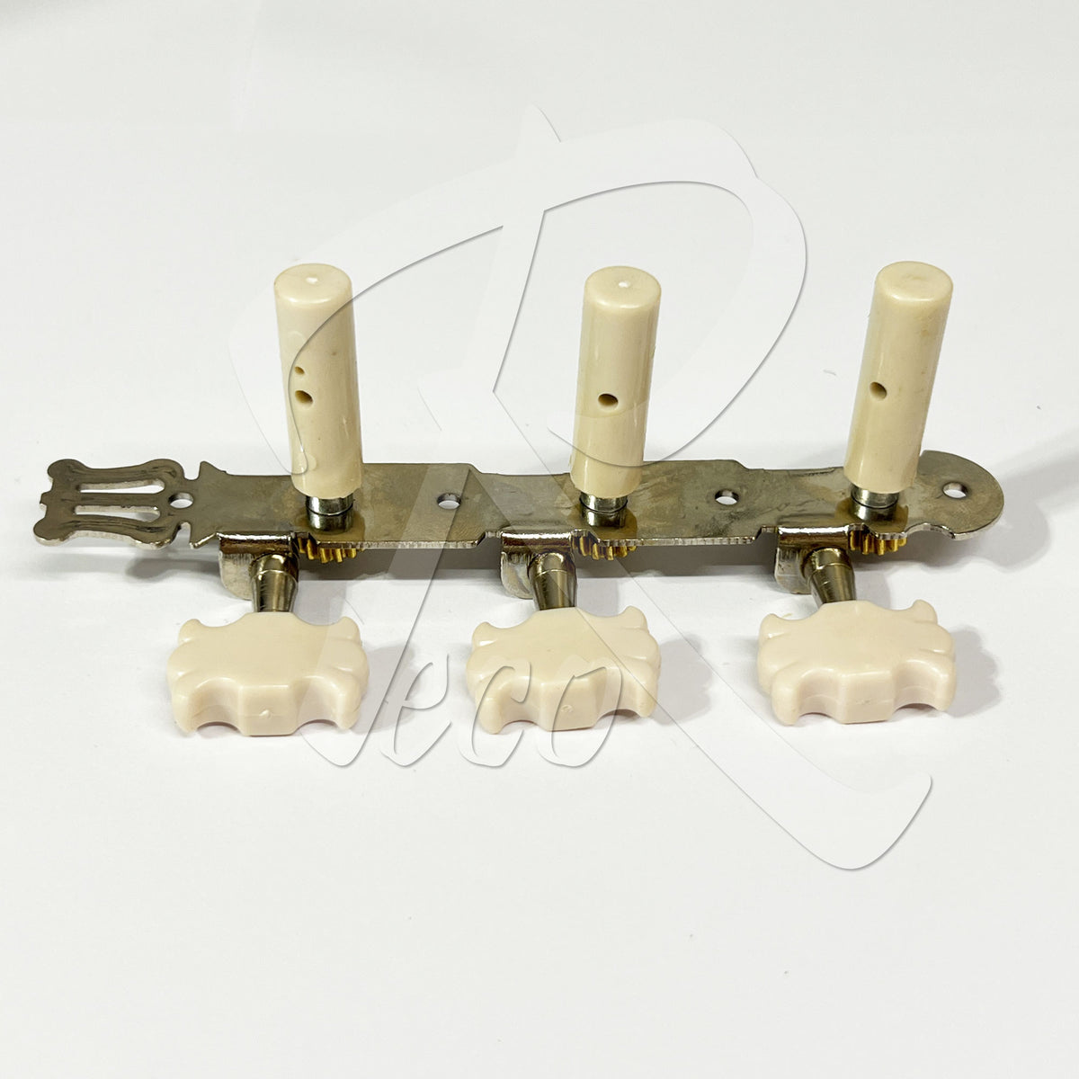 A vintage-style four-string guitar tailpiece with cream-colored bone or ivory knobs and peg legs, a brass-toned metal bar, and three matching pegs, shown on a plain white background.