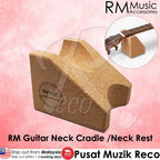 A cork guitar neck cradle shown on a pink background, with a small inset showing part of a guitar neck resting on it. Text includes RM Music Accessories branding and Malay text describing the product.